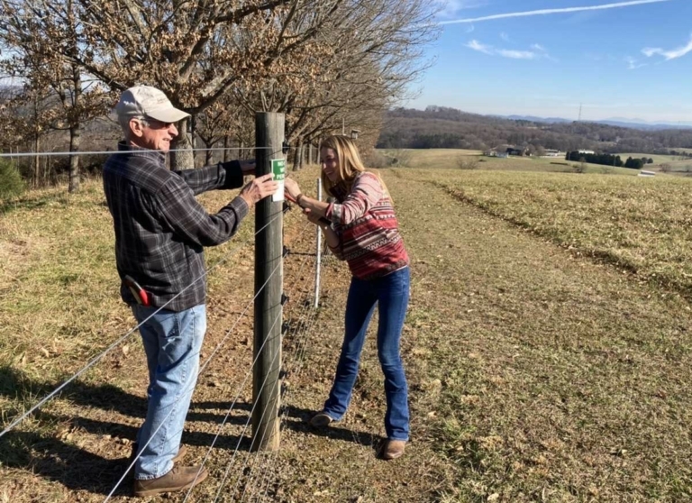 Landowner Glen Savage and FLC Biologist Shelby Lyn Sanders place FLC conservation easement boundary signs along the property. 768x558